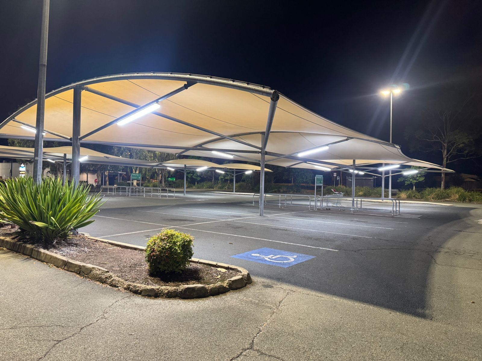 LED lighting under shade sails in a shopping centre car park at night