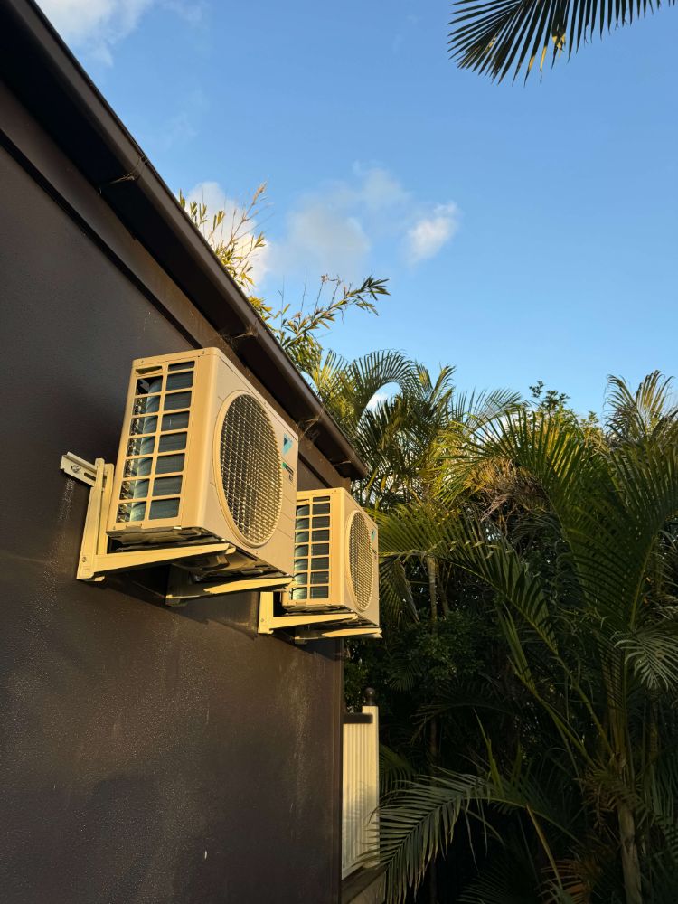 Two split system outdoor units mounted on wall brackets