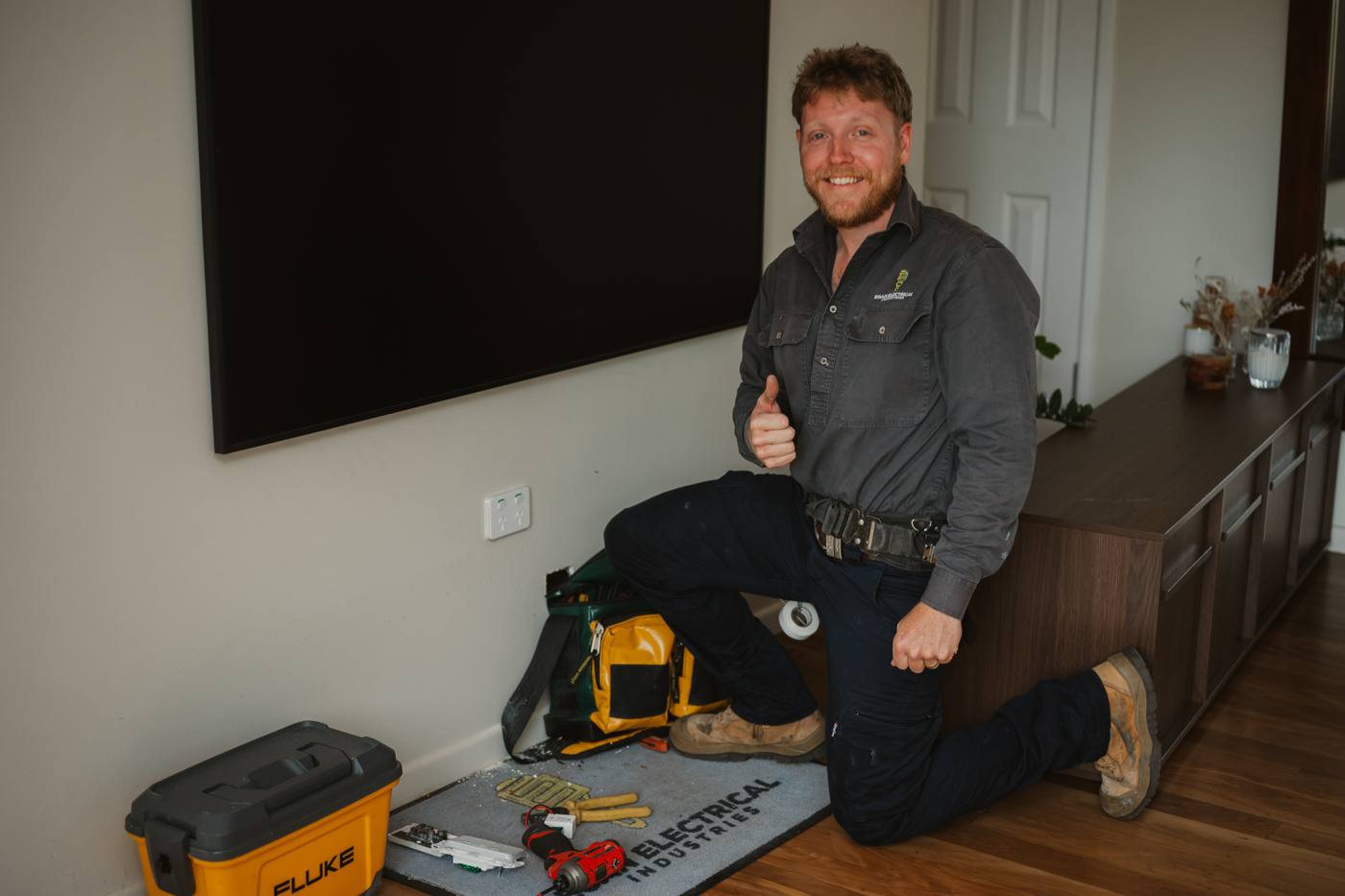 Electrician giving a thumbs up after installing a power point