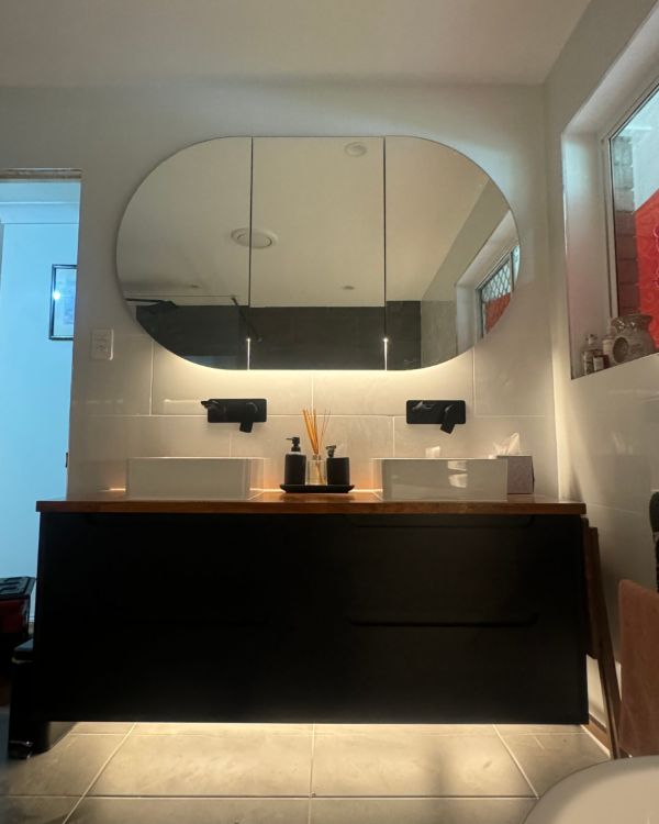 LED strip lighting under a bathroom vanity and behind a mirror in Warner