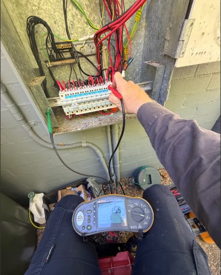 Electrician testing a switchboard with a Fluke multifunction tester